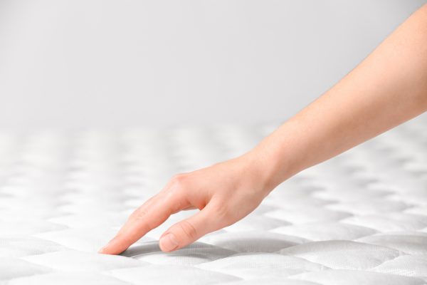 Woman touching orthopedic mattress