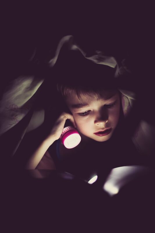 child reading book at night